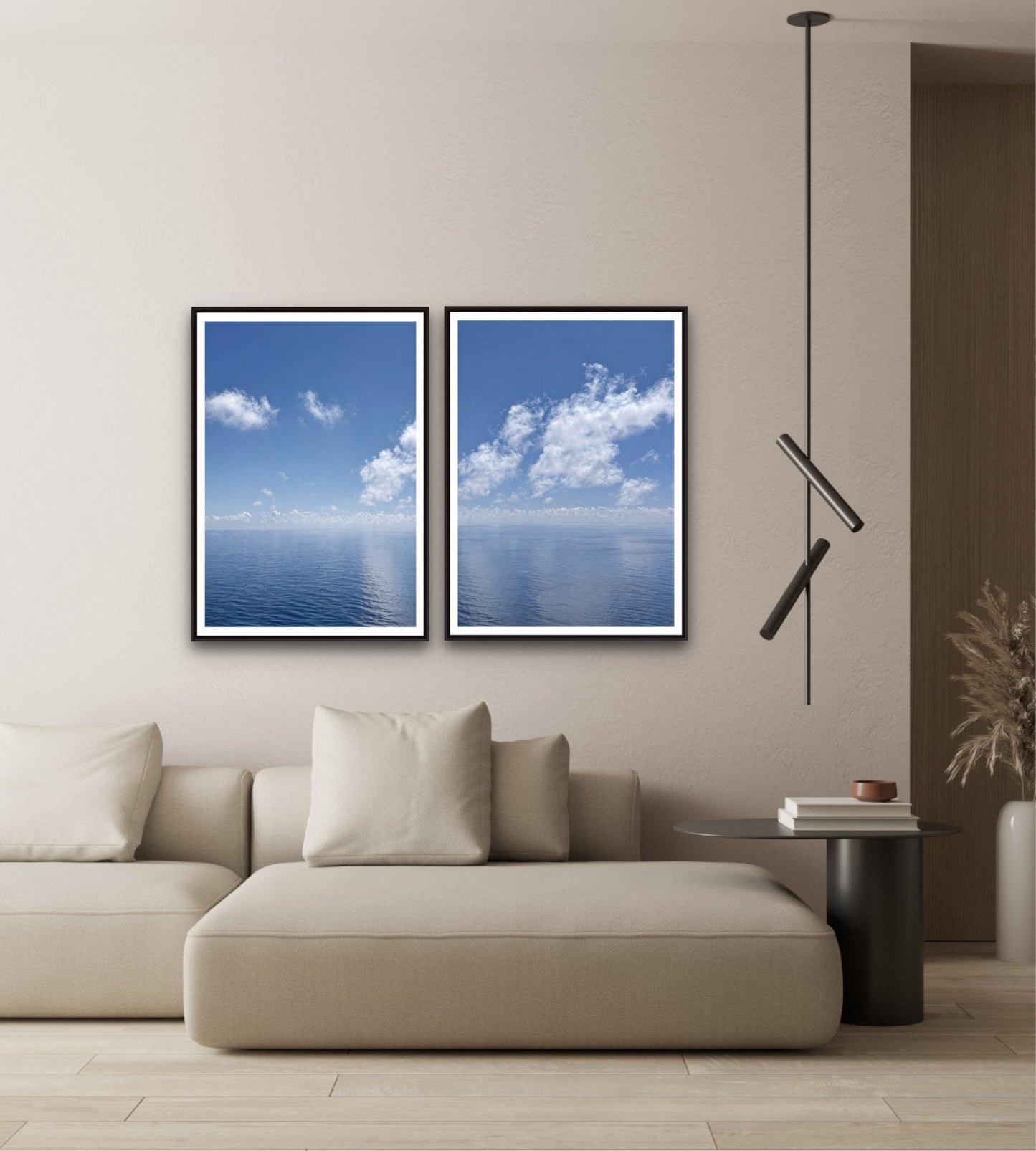 Modern living room with a beige sofa, two framed blue sky and cloud pictures, and a pendant light.