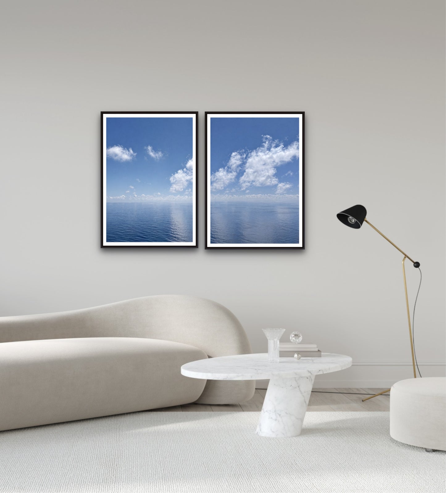 Two framed pictures of blue skies with clouds on a wall above a sofa.