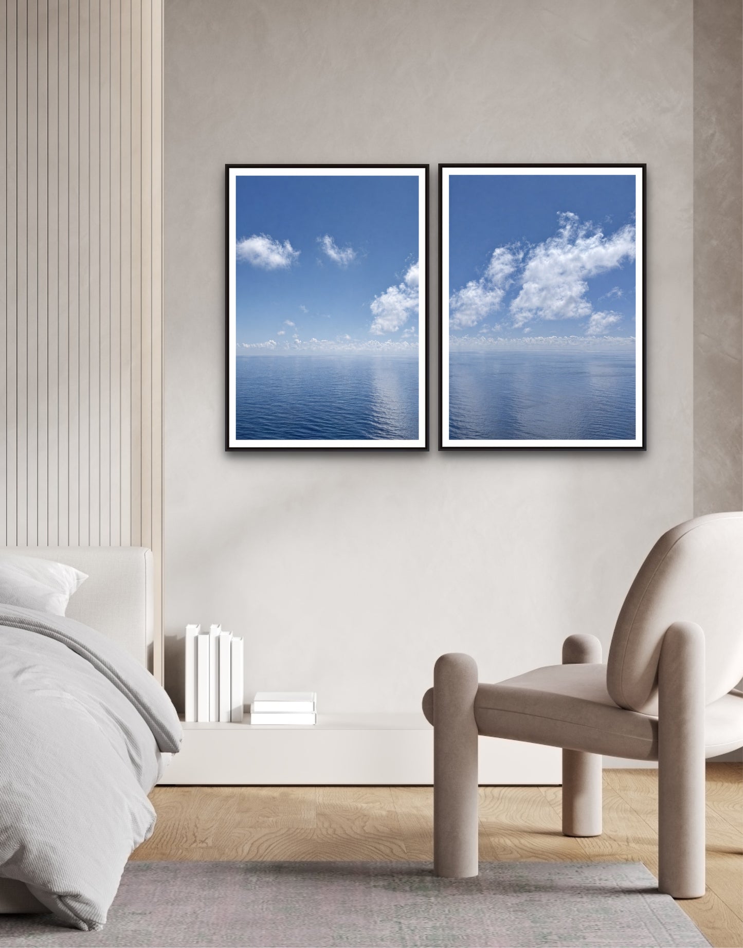 Two framed images of a blue sky with clouds on a wall above a bed.