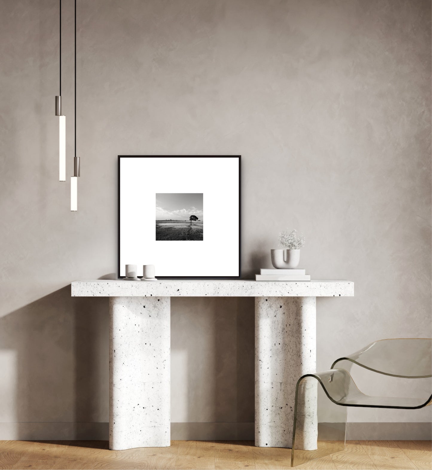 Modern interior with a concrete console table, framed black and white photo, and a clear glass chair.