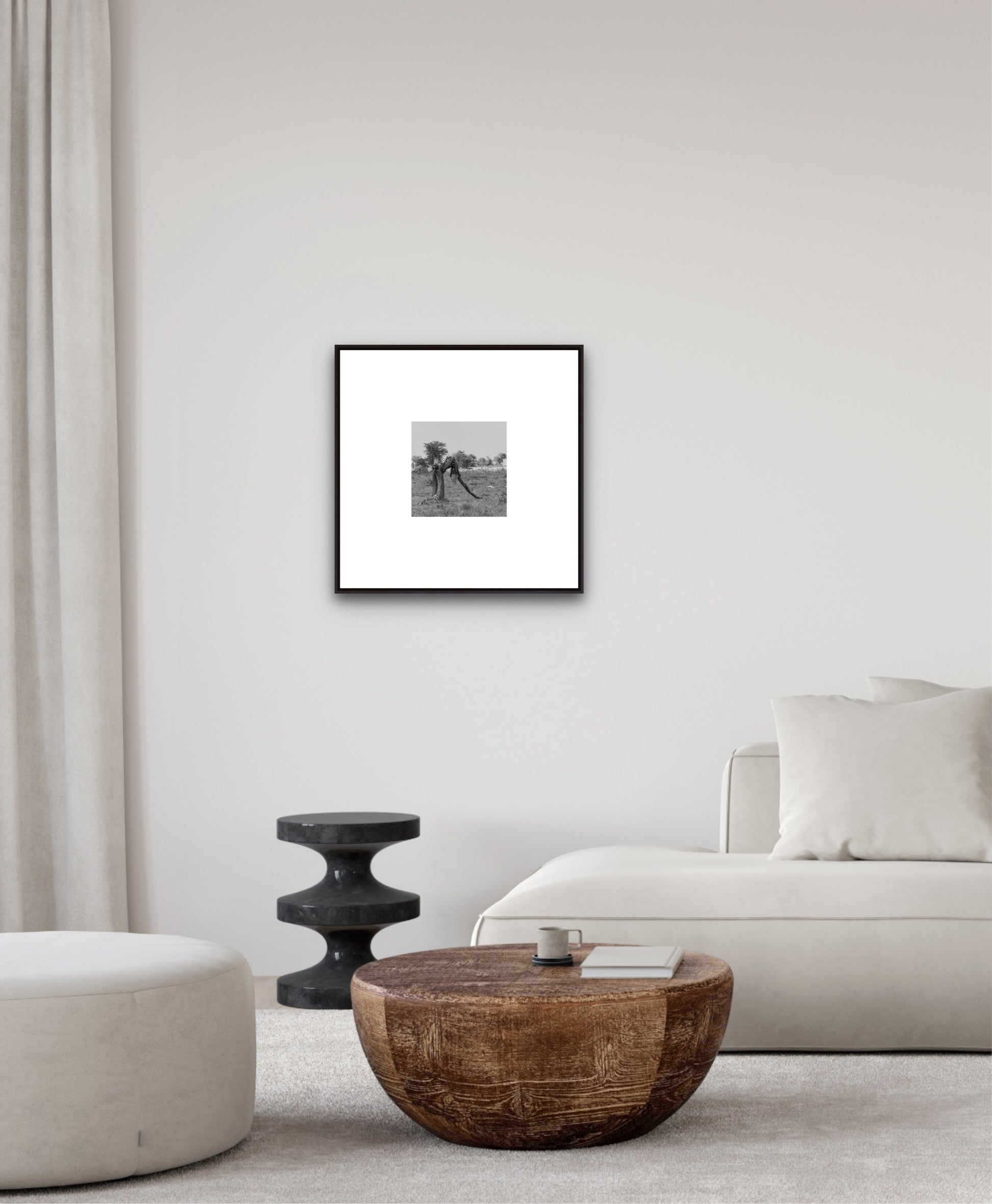 Framed black and white photograph on a wall above a wooden coffee table in a living room.