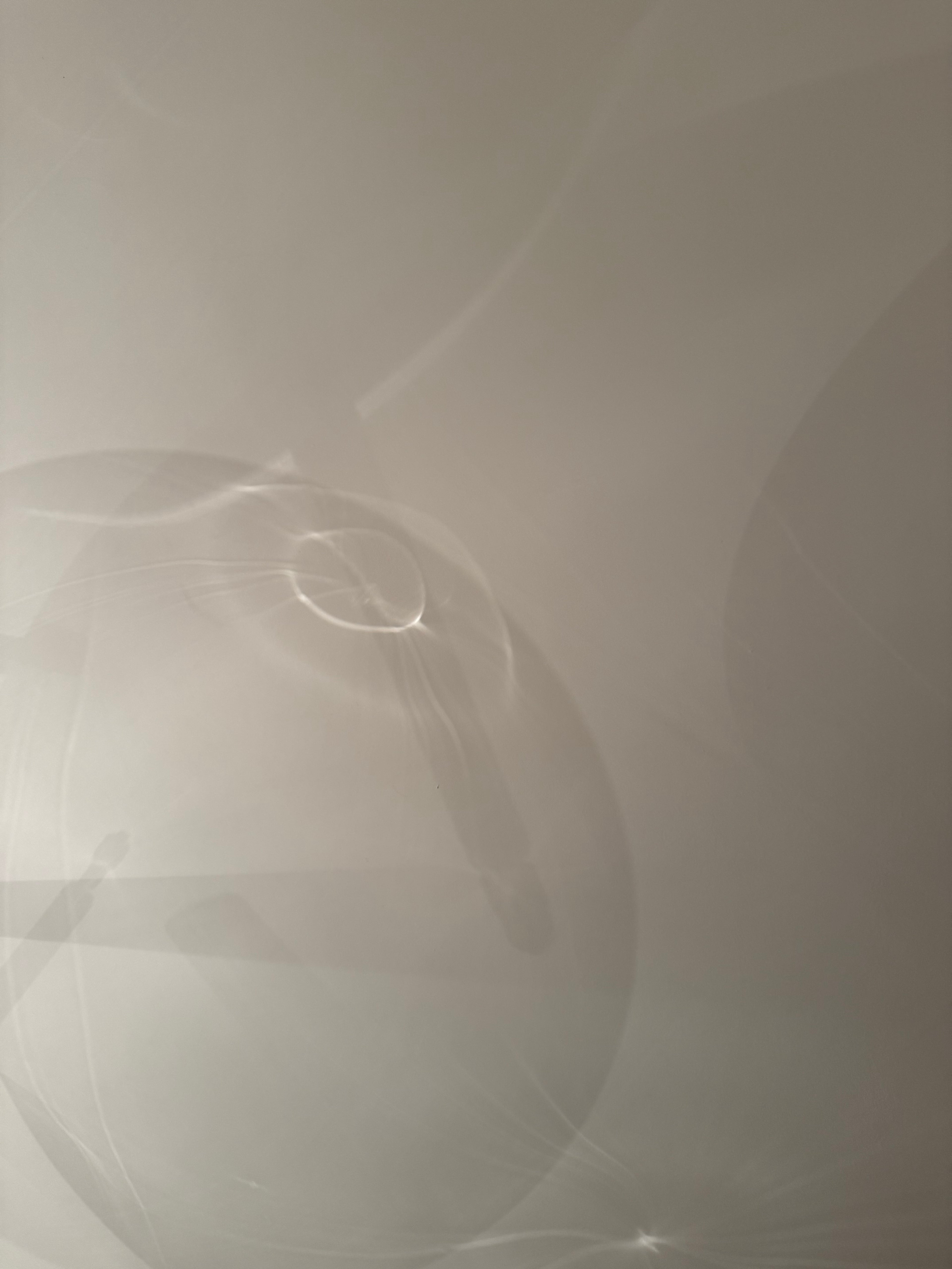 Close-up of reflex of a glass lamp on a white wall